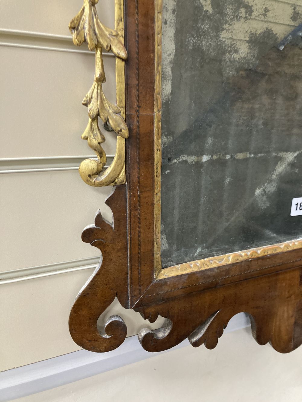 A George II parcel gilt walnut fret cut wall mirror, width 56cm height 120cm